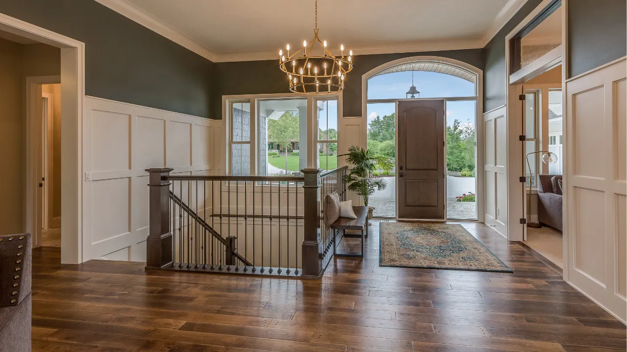 Warm mid-tone wood-look flooring in a bright entry with white wainscoting and dark painted walls